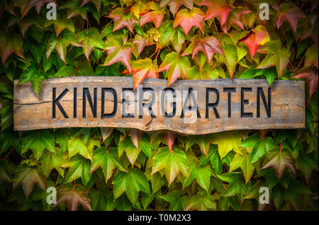 Rustikale Holz geschnitzte Kindergarten Zeichen gegen einen schönen grünen Hintergrund Stockfoto