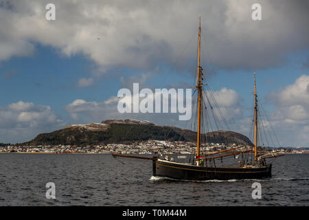 Eine kleine hölzerne Segelschiff auf dem Wasser außerhalb der Stadt Alesund in Norwegen. Stockfoto