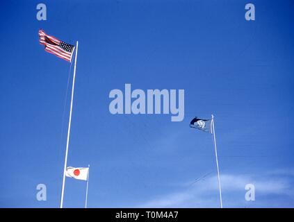 Froschperspektive, an einem sonnigen Tag, der amerikanischen, japanischen und Vereinten Nationen flags Flying von fahnenmasten, Camp Schimmelpfennig, Sendai, Präfektur Miyagi, Japan, 1952. () Stockfoto