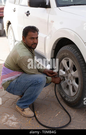 Mann Pumpen nach oben Reifen von 4WD wieder nach der Reise in die Wüste. Stockfoto