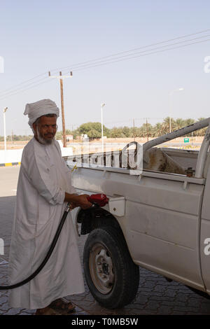 Omanische Mann befüllen Fahrzeug mit Benzin an der Tankstelle in der Nähe der Wüste Stockfoto