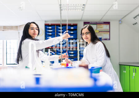 Zwei Zwillingsschwestern, die Wissenschaft studieren in der Hochschule in Cambridge forschen Experimente im Labor, Stockfoto