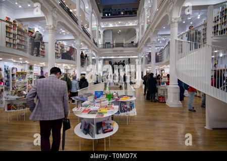 Personen innerhalb der Bibliothek auf der Suche rund um Bücher. Atemberaubende Architektur Innenarchitektur Stockfoto