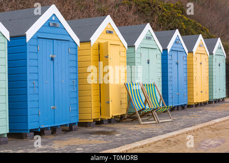 Zwei Liegestühle außerhalb Holzhütten am Bournemouth, Dorset UK im März Stockfoto