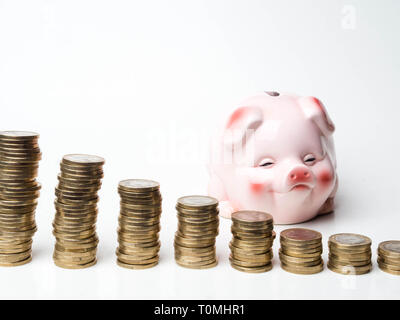 Konzept Bild für die finanzielle Planung. Lpink kreativ Sparschwein und gestapelte Münzen vor einem weißen Hintergrund. Kopieren Sie Platz. Stockfoto