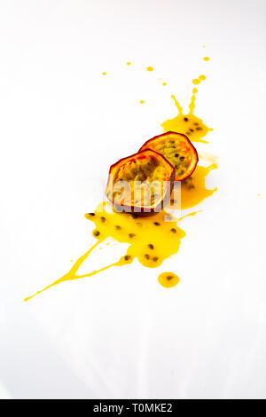 Passionsfrucht splasing. in Stücke oder Scheiben geschnitten, Passionsfrucht. Schmiert oder Blot der Leidenschaft Fruchtsaft auf weißem Hintergrund. Exotische Früchte Stockfoto