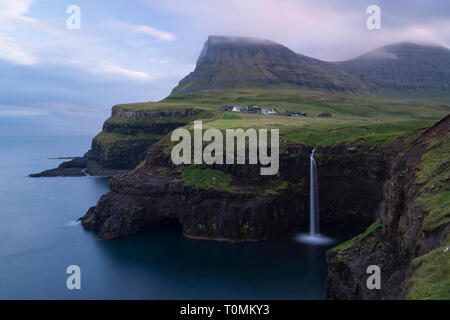 Dämmerung auf der Steilküste mit Wasserfall in Gásadalur, Vágar, Färöer, Dänemark Stockfoto