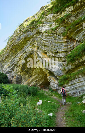 Junge Frau erreichen Der Arpea Höhle, eine spektakuläre Antiklinale Falten wie ein Pferd Zuflucht in der französischen Pyrenäen nahe der spanischen Grenze (Estérençuby, Frankreich) Stockfoto