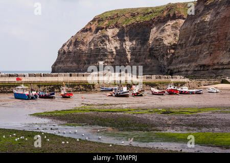 Boote im Hafen bei Ebbe im Fischerdorf Staithes, North Yorkshire, England, Großbritannien Stockfoto