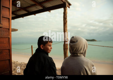 9 Jahr alt und 7 Jahre alten Jungen außerhalb eines Lean Beach Hut auf Putney Strand, Great Keppel Island, Queensland, Australien Stockfoto