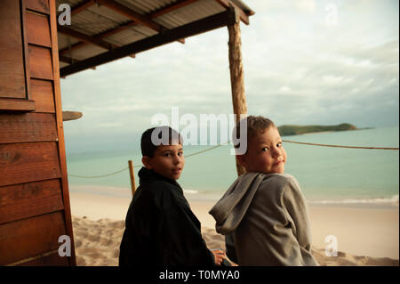 9 Jahr alt und 7 Jahre alten Jungen außerhalb eines Lean Beach Hut auf Putney Strand, Great Keppel Island, Queensland, Australien Stockfoto