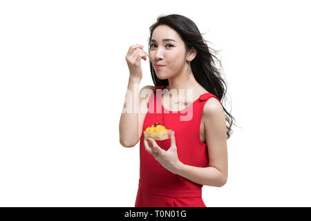 Glückliche junge Frau Kuchen essen Stockfoto