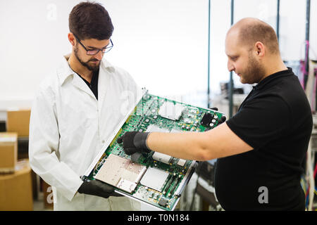 Portrait der junge Ingenieur holding CMTS Karte Stockfoto