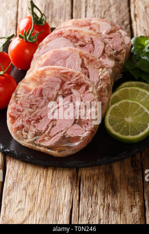 Frisch geschnittene Brawn mit Tomaten, Limone und Koriander closeup auf einer Schiefertafel Brett auf den Tisch serviert. Vertikale Stockfoto