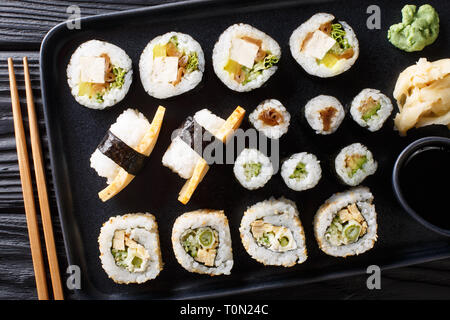 Die japanischen Hosomaki rollt, Uramaki, Maki, Nigiri, Tamagoyaki mit verschiedenen Füllungen close-up auf einem Teller auf den Tisch. Horizontal oben Ansicht von oben Stockfoto
