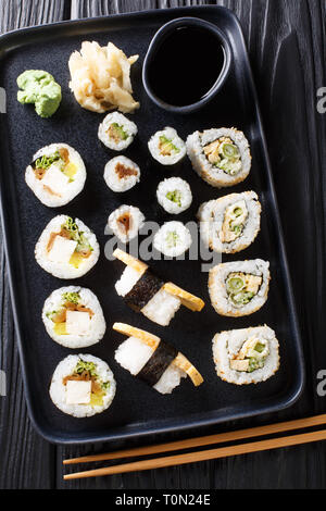 Köstliche japanische Sushi Rollen große mit Meeresfrüchten, Gemüse, Tofu und tamago Closeup auf einem Teller auf den Tisch gesetzt. Vertikal oben Ansicht von oben Stockfoto