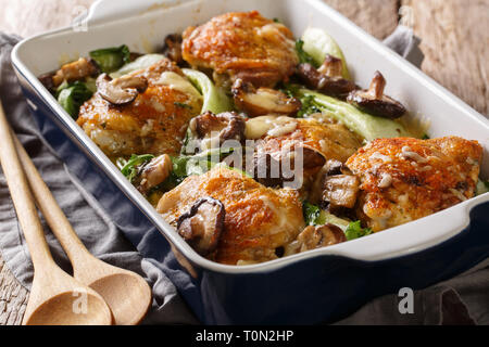 Gesundes Essen gebackene Hühnerkeule mit Baby Bok Choy, Shiitake Pilze und Käse Sauce in einem rustikalen Stil Nahaufnahme auf dem Tisch. Horizontale Stockfoto