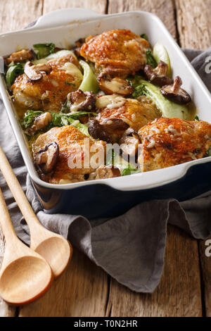 Hühnerkeule mit Baby Bok Choy, Shiitake Pilze und Käse Sauce in einem rustikalen Stil close-up auf dem Tisch. Vertikale Stockfoto