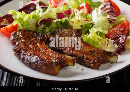 Gebratenes Lamm, Steak mit frischen Salat close-up auf einem Teller auf den Tisch. Horizontale Stockfoto