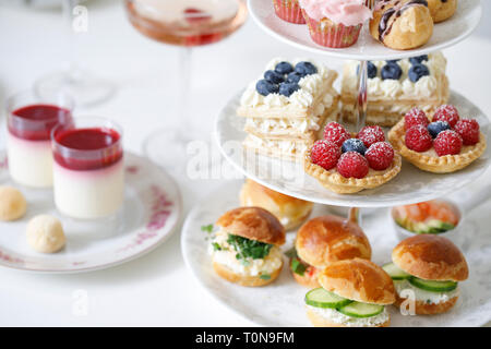 Nachmittagstee mit Mini brioche Kanapees und Auswahl an Süßigkeiten Stockfoto