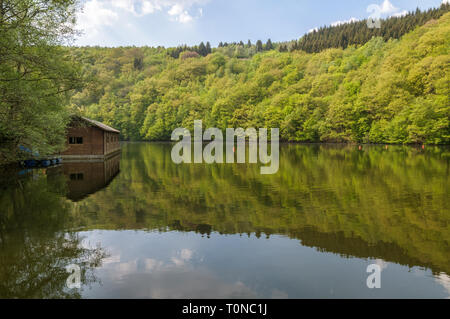 Blick auf den See Nisramont und das Bootshaus im Frühjahr mit schönen Reflexionen und frische grüne Blätter an den Bäumen. Der See ist durch ein Wehr in gebildet Stockfoto