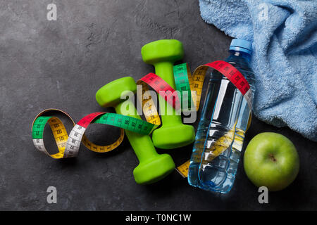 Fitness Concept. Kurzhanteln, Maßband und Apple auf Stein Hintergrund. Ansicht von oben mit Platz für Ihren Text Stockfoto