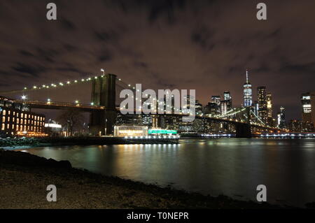 Brooklyn Bridge bei Nacht mit Manhattan Skyline im Hintergrund, von Dumbo, Brooklyn. Stockfoto
