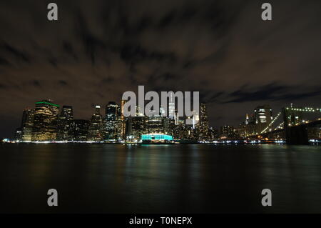 Manhattan Skyline von Dumbo, Brooklyn in der Nacht, mit der Brooklyn Brücke auf der rechten Seite. Stockfoto