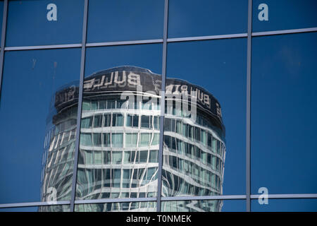 Birmingham, England - 17. März 2019: Birmingham Wahrzeichen der Rotunde, spiegelt sich in der Glasscheibe des Bull Ring Brücke aus gesehen Smallbrook Stockfoto