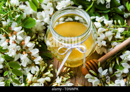 Akazienblüten und natürlichem Honig im Glas Stockfoto