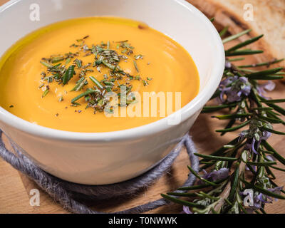 Weiche, cremige Kürbissuppe in einer Schüssel auf Holz Hintergrund. gesunde Gemüse püriert mit Thymian auf der Oberfläche Stockfoto