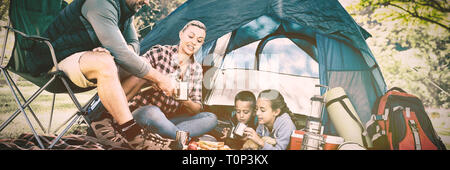 Familie mit Snacks und Kaffee außerhalb des Zeltes Stockfoto