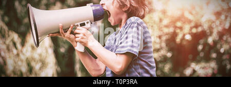 Ein kleiner Junge ist mit einem Megaphon schreien. Stockfoto