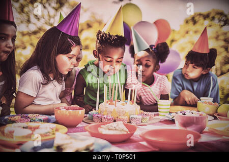 Süße Kinder weht zusammen auf die Kerze in einen Geburtstag feiern Stockfoto