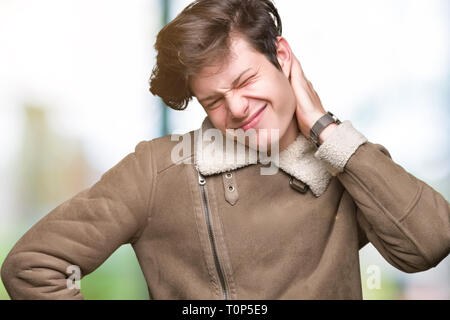 Jungen gutaussehenden Mann tragen Winter Mantel über isolierte Hintergrund Leiden der Nacken Schmerzen Verletzungen, Hals mit der Hand berühren, Muskelschmerzen Stockfoto