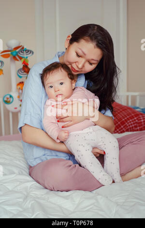 Porträt der schönen gemischten Rennen asiatischen Mutter Holding berühren, umarmen Sie cute adorable neugeborenes Baby. Frühe Entwicklung und Gesundheit leben Stockfoto