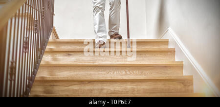 Älterer Mann unten Klettern mit Stock Stockfoto