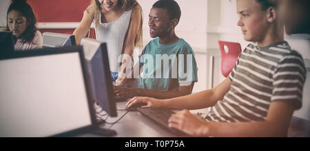 Studenten, die mit Computer im Klassenzimmer Stockfoto