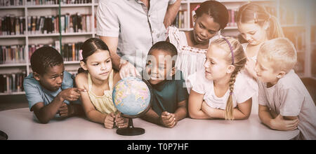 Lehrer und Schüler im Globe Suche in Bibliothek Stockfoto
