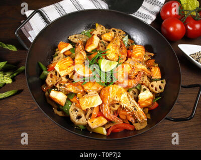 Wok mit Garnelen, Lachs und Nudeln Stockfoto