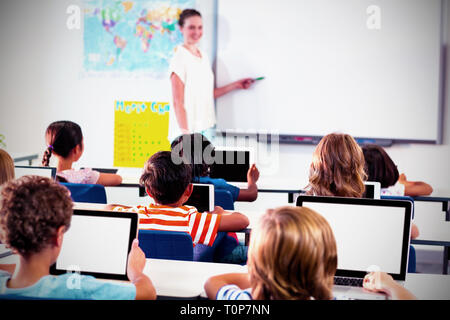 Kinder mit digitalen Tabletten mit Lehrer Lehre Stockfoto