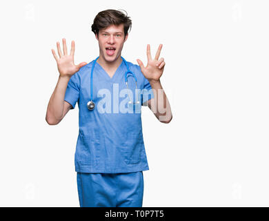 Junger Arzt mit medizinischen gleichmäßig über isolierte Hintergrund angezeigt und zeigen mit den Fingern die Zahl 8 Während lächelte zuversichtlich und fröhlich. Stockfoto