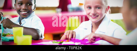 Kinder während der Pausen in der Cafeteria der Schule zu Mittag Stockfoto