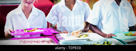 Porträt von Schulkindern mit Mittagessen während der Pausenzeit Stockfoto