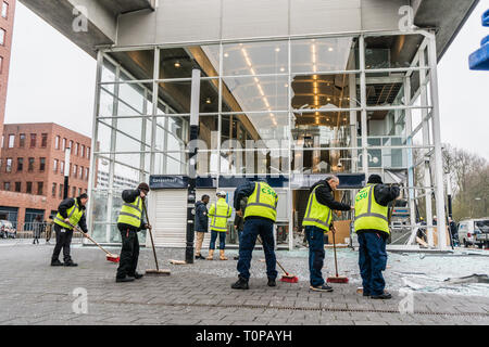 Amsterdam, Niederlande. 21 Mär, 2019. Arbeitnehmer der CSU Reinigung Firma fegt die Glas Mangold gemeinsam vor der beschädigten Eingang op Metrostation Ganzenhoef. Credit: Steppeland/Alamy leben Nachrichten Stockfoto