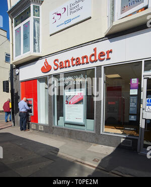 Mann, der den Geldautomaten in einer Zweigstelle von Santander, Driffield, East Yorkshire, benutzt, Shopper, die das warme Frühlingswetter auf dem Driffield Street Market genießen. Kredit: Alan Mather/Alamy Live Nachrichten Stockfoto