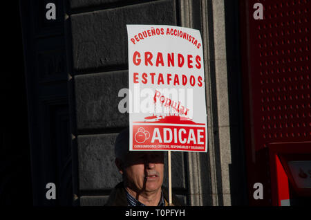 Madrid, Spanien. 21. Mär 2019. Scammed Aktionäre protestierten vor der Bank "Banco Popular" Teil der Santander Gruppe in Madrid. Rund 300 000 shareholdres wurden mit kein Geld auf Ihren Konten. Im Bild, ein Mann in den Protest Holding eine Plakette, die besagt, dass "kleine Aktionäre, großer Betrug." Credit: Lora Grigorova/Alamy leben Nachrichten Stockfoto