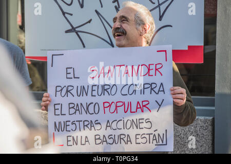 Ein Mann mit einem Plakat mit dem Motto der Santander Bank für 1 Euro kauft die Bank und unsere Anteile in den Papierkorb. Demonstration gegen die Popular Bank, der Gruppe der Santander Bank durch die kleinen Aktionäre im Jahr 2018 betrogen. 305.000 Aktionäre ihr Geld für die Pleite der Bank verloren. Durch den Betrug in der Gruppe der Emilio Saracho mit der Bank von Spanien ausgeführt. Credit: Alberto Sibaja Ramírez/Alamy leben Nachrichten Stockfoto