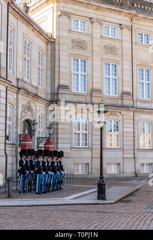 Kopenhagen, Dänemark - 19. März 2019: Die Royal Life Guards (Den Kongelige Livgarde) März von Schloss Rosenborg um 11.30 Uhr täglich durch die Straßen von Kopenhagen, und führen Sie die Wache im Inneren Platz der Paläste (oder Villen) von Schloss Amalienborg. Brambilla Simone Live News Fotograf Stockfoto