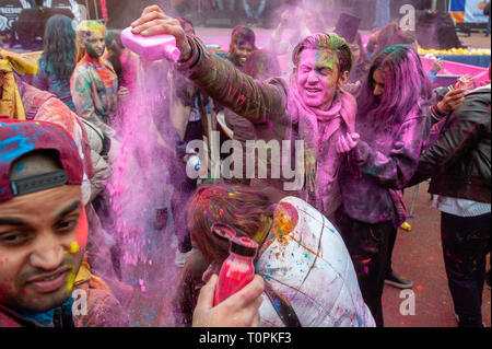 Ein Mann wird gesehen, werfen farbigen Pulvern bis zu einer Frau. Millionen von Menschen auf der ganzen Welt feiern die jährliche Holi Hangámá Festival, auch als das Fest der Farben genannt. Für die Hindus ist es eine Feier der Ankunft des Frühlings, das Neue Jahr und Sieg in einem. Den größten indischen Bevölkerung in Europa (außerhalb des UK) können in Den Haag, gefunden werden Dies ist einer der größten in Europa. Das Highlight der Holi Feiern ist der Umzug durch die multikulturellen Transvaal und Schilderswijk Nachbarschaften. Die Teilnehmer an der Prozession werfen Bunte Pulver an sich selbst und an ea Stockfoto